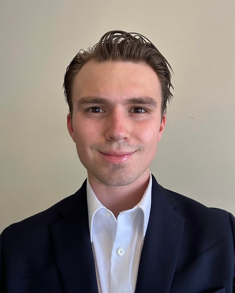 Headshot of Devin Yarak in a navy blazer and white shirt